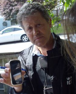 VPD detective constable Rainey holding a phone stolen by cops during June 3, 2014 raid.