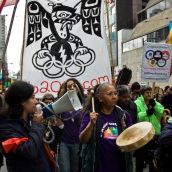 anti-olympic activists make their way through downtown vancouver