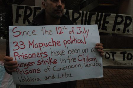 Claudio Escobar with a sign in support of the Mapuche hunger strikers