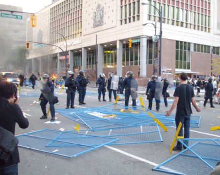 Riot cop advance blocked by dismantled fencing