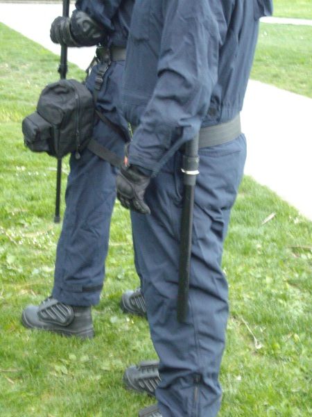 This second deployment saw PSU members wearing coveralls with body armour, 3 foot long riot batons, and gas masks strapped to their legs.
