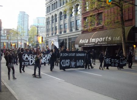 Marching east on Hastings Street carrying torches.