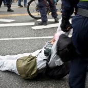 Riot Police drag an activist away