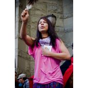 A First Nations women holds up an eagle feather in memory of those who have passed